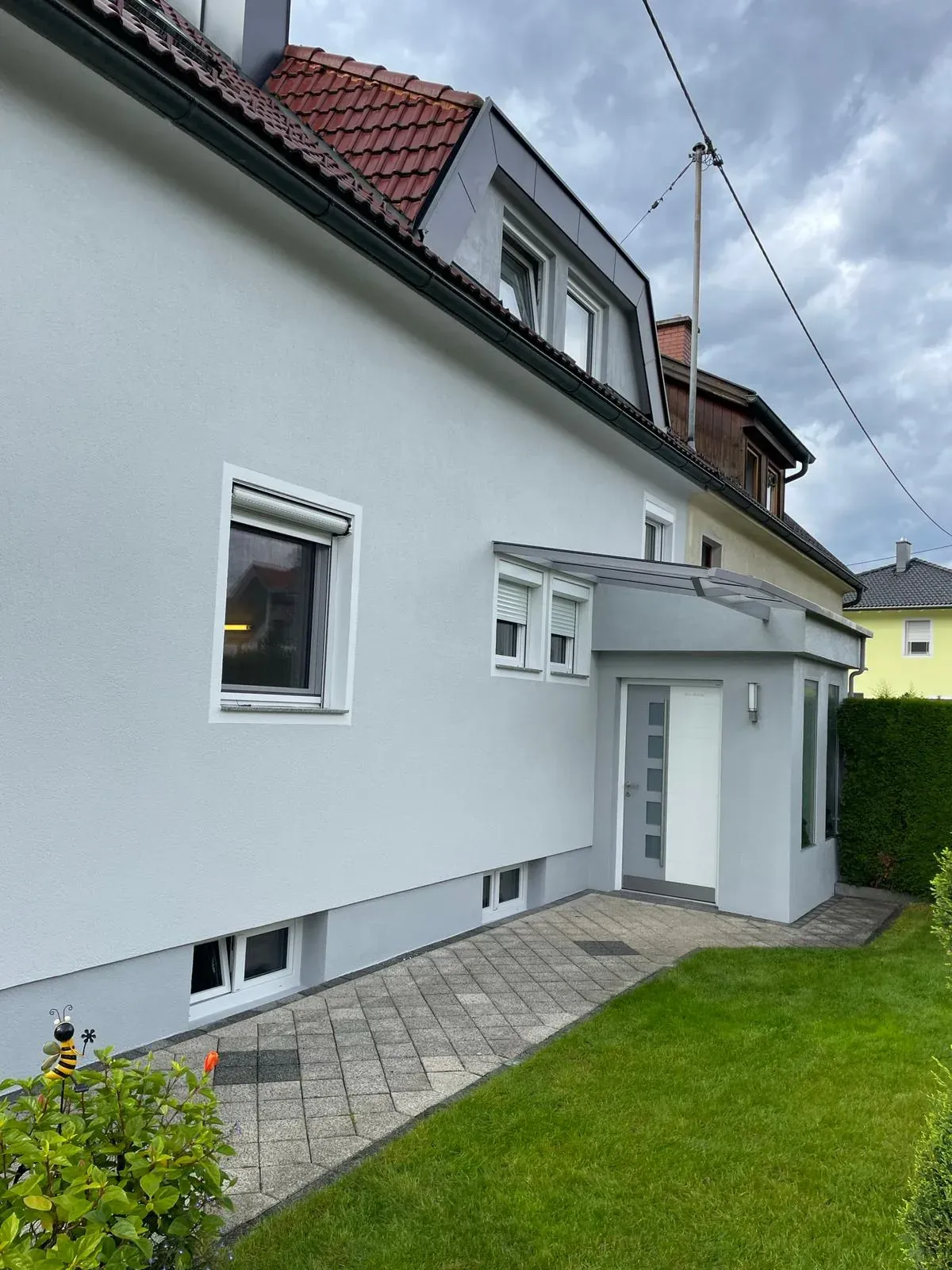 Sanierte Stadthaus-Fassade in graugewaschenem Ton, Klagenfurt